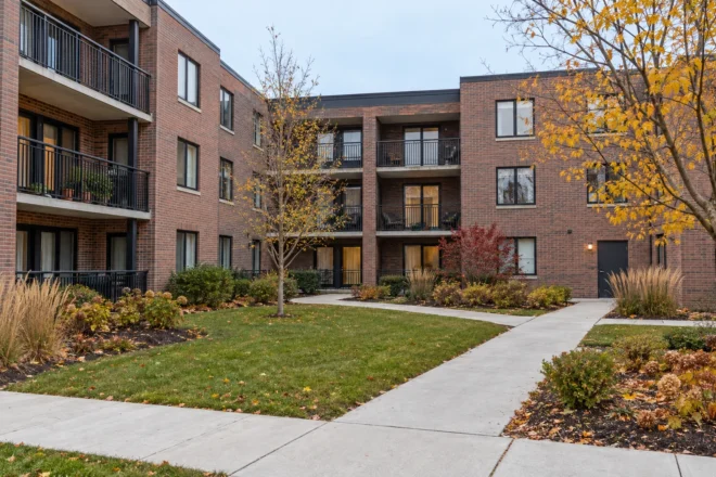 Autumn condominium courtyard with clear shared walks, tidy lawn and retained seasonal planting.
