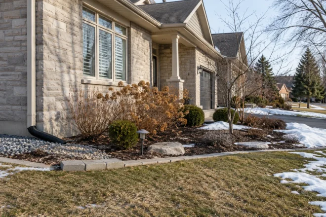 Downspout extension in a front garden during snowmelt